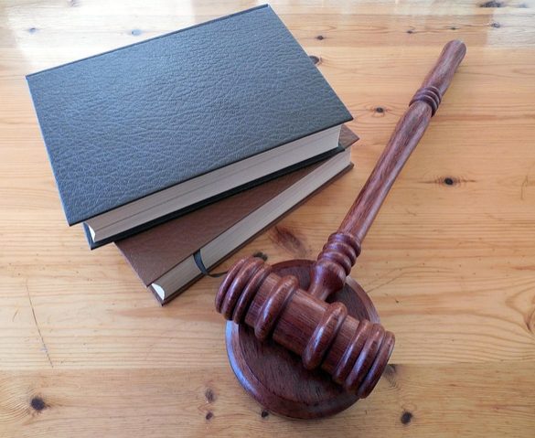 Judge's hammer and books on top of a wooden table